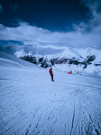 People skiing on snowcapped mountain against sky