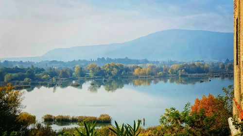 Scenic view of lake by trees against sky