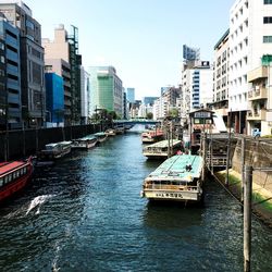 Canal amidst buildings in city against sky