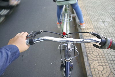 Cropped hand riding bicycle on street