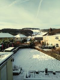 High angle view of townscape by snowcapped mountain against sky