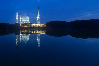 Reflection of building in lake against blue sky