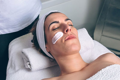 Midsection of woman lying on bed