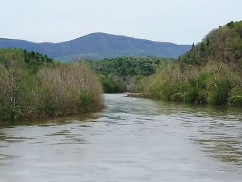 Scenic view of river amidst mountains against sky