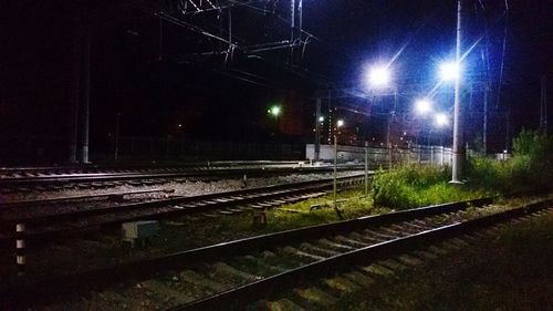 Railroad tracks in city at night