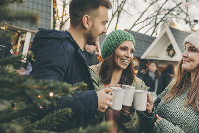 Three friends having a hot punch on the christmas market