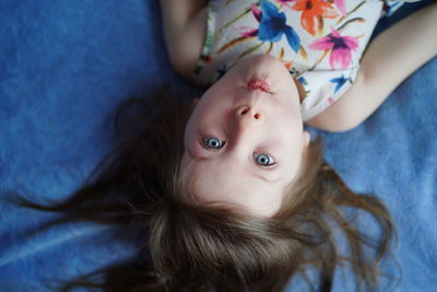 High angle view of young woman lying on bed at home