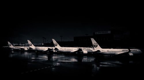 Airplane at airport runway against sky at night