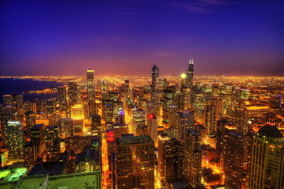 High angle view of illuminated buildings against sky at night