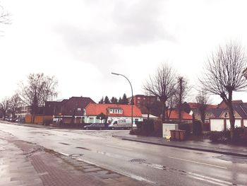 Cars on city street against sky