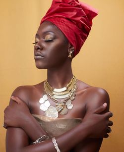 Portrait of a culture  young woman standing against yellow background