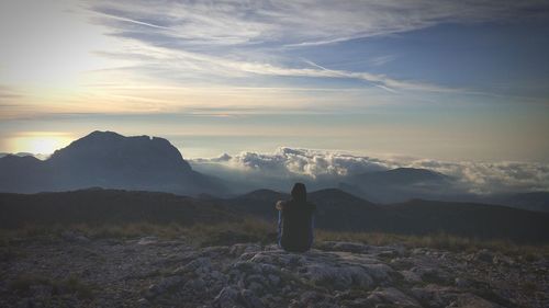 Woman looking at mountains against sky