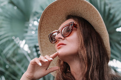 Close-up portrait of young woman wearing hat