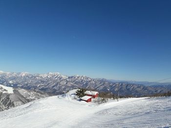 Scenic view of snowcapped mountains against clear blue sky