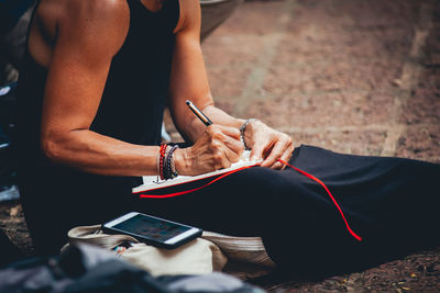 Midsection of woman using mobile phone