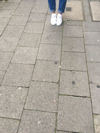 Low section of man standing on cobblestone