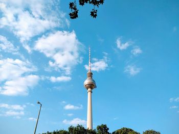 Low angle view of television tower against cloudy sky