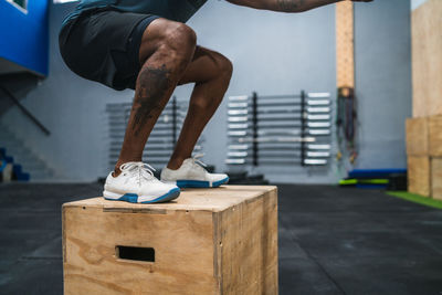 Low section of man standing on box in gym