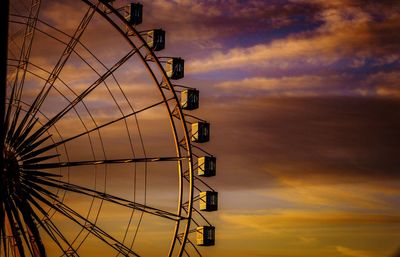 Low angle view of ferris wheel against sky at sunset