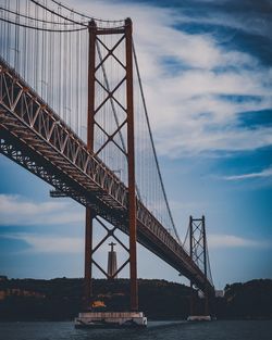 Low angle view of ponte 25 de abril in lisbon against sky during sunset