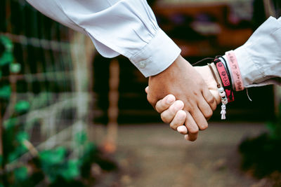 Cropped image of couple holding hands