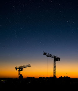 Cranes against sky at night