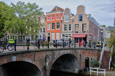 Utrecht, the netherlands. a line of bikes parked on a bridge over the oudegracht canal.