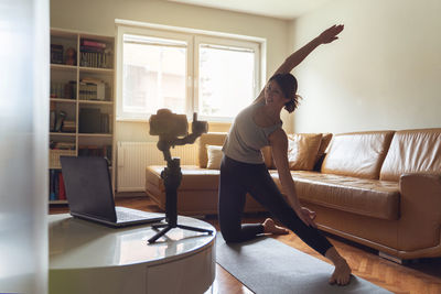 Woman standing on sofa at home