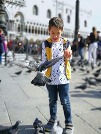 Full length portrait of boy standing in city