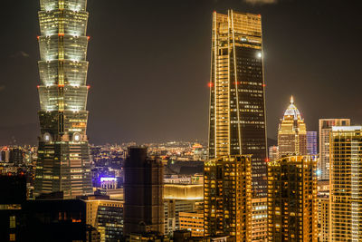 Illuminated buildings against sky at night