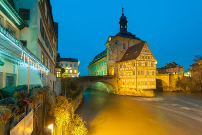 Illuminated buildings against clear sky at night