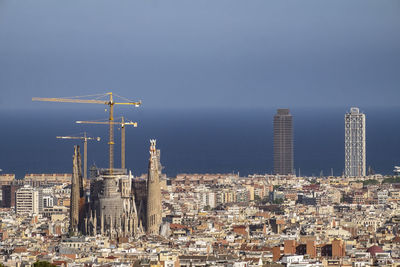 Aerial view of buildings in city against clear sky