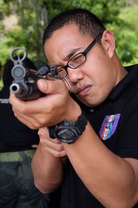 Man in eyeglass aiming with gun