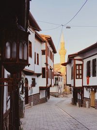 Houses by street against sky in city