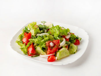 Close-up of salad served in plate against white background