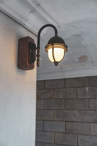 Low angle view of light bulb on wall