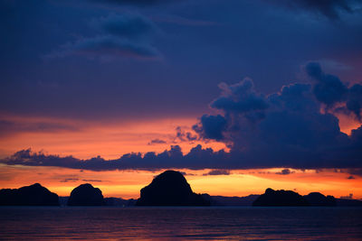 Scenic view of sea against dramatic sky during sunset