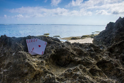 Scenic view of rocks on beach against sky