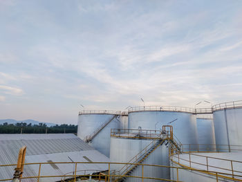 Low angle view of crane against sky. tank oil industry factory