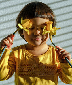 Close-up portrait of a girl holding flower