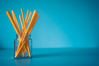 Close-up of glass bottle on table against blue background