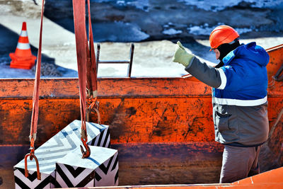 Rear view of man working in boat