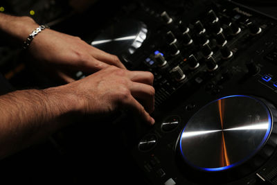 Cropped hands of man mixing music in recording studio