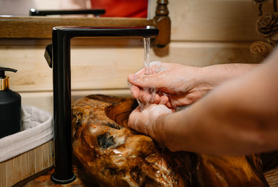 Cropped image of man washing hands