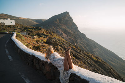 Woman on mountain against sky