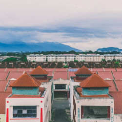 Houses in town against cloudy sky