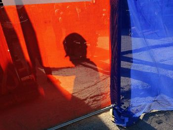 Shadow of worker on red textile at construction site