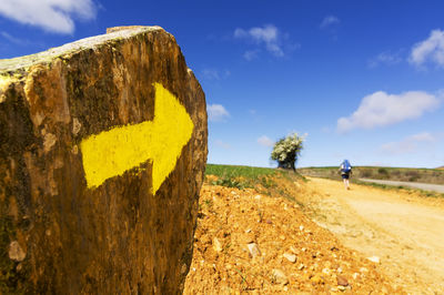 Man walking on field with arrow symbol in foreground