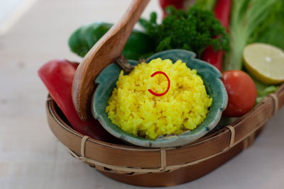 Close-up of nasi kuning in basket on table, indonesian traditional turmeric rice dish