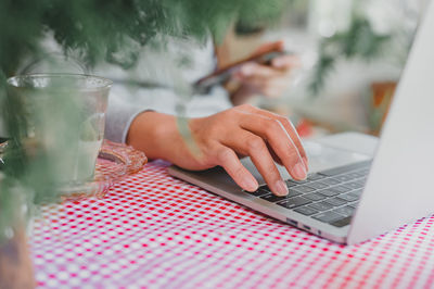Midsection of man using mobile phone on table